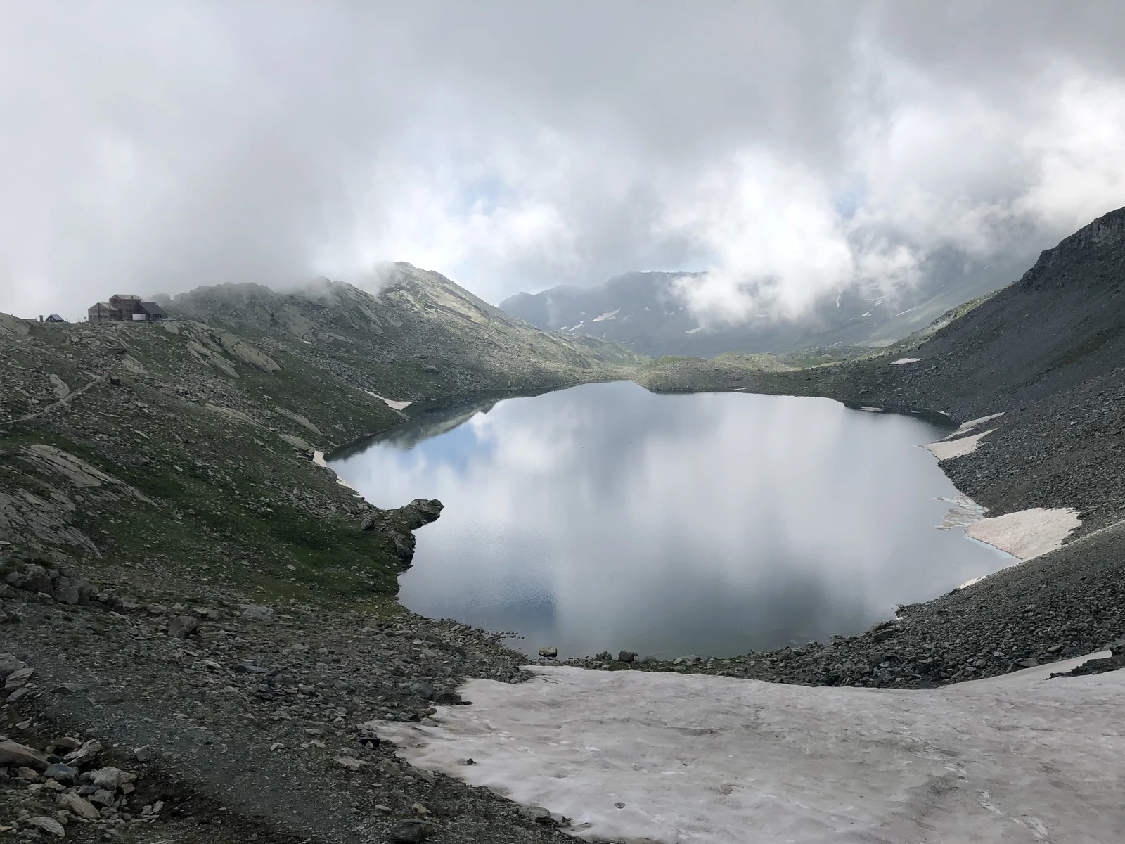 Lago, neve residua e nuvole nella parte alta dell’itinerario