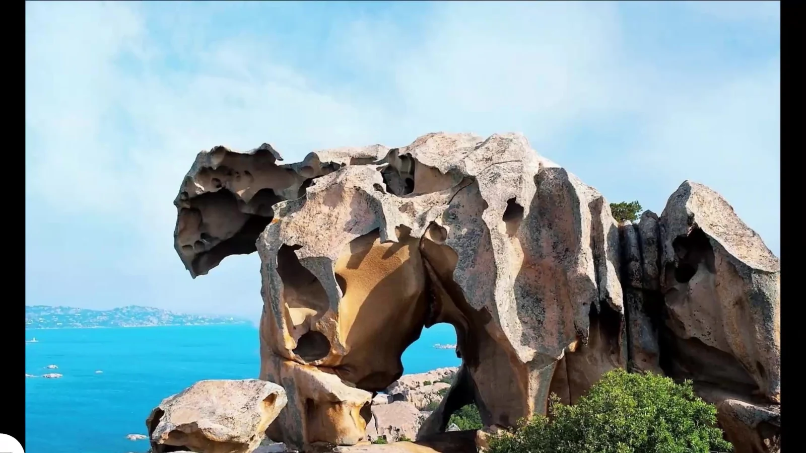 Grande formazione granitica modellata dal vento davanti al mare